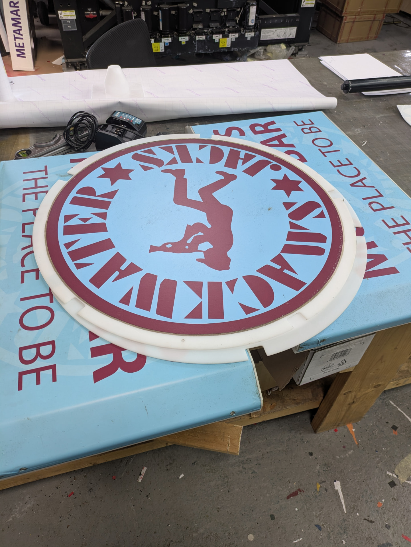 Newly printed Smackwater Jacks circular sign face in the TCB workshop