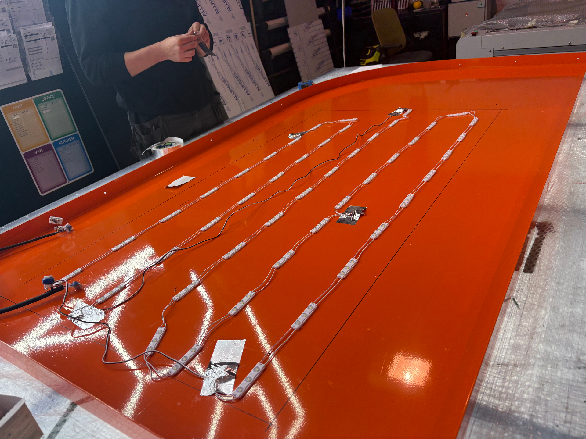 Internal LED module rows being installed inside the orange totem face for even illumination