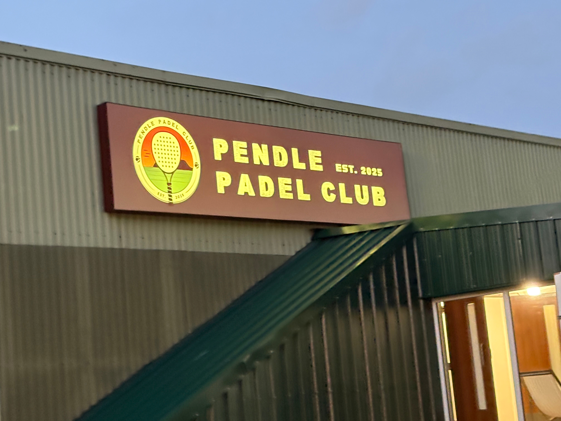 Pendle Padel Club illuminated flex face exterior sign with crest logo lit at dusk