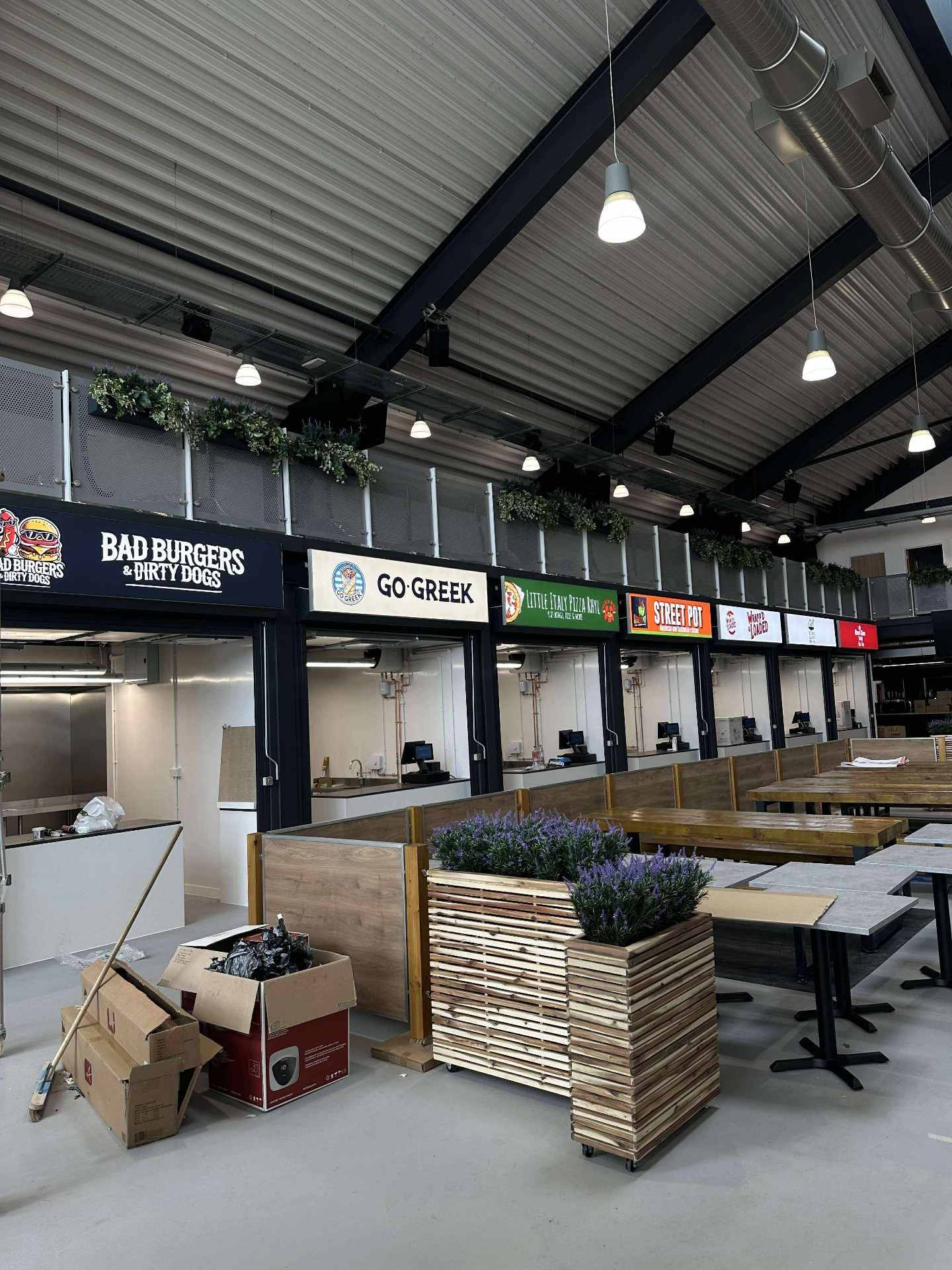 Food court tenant fascia signs at Queen's Market — Bad Burgers, Go Greek, Little Italy, Street Pot and more